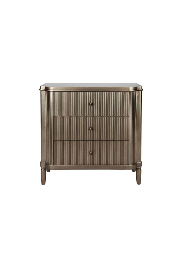 Art-deco style chest of drawers with round edges, a ribbed antique gold finish and three drawers on a white background