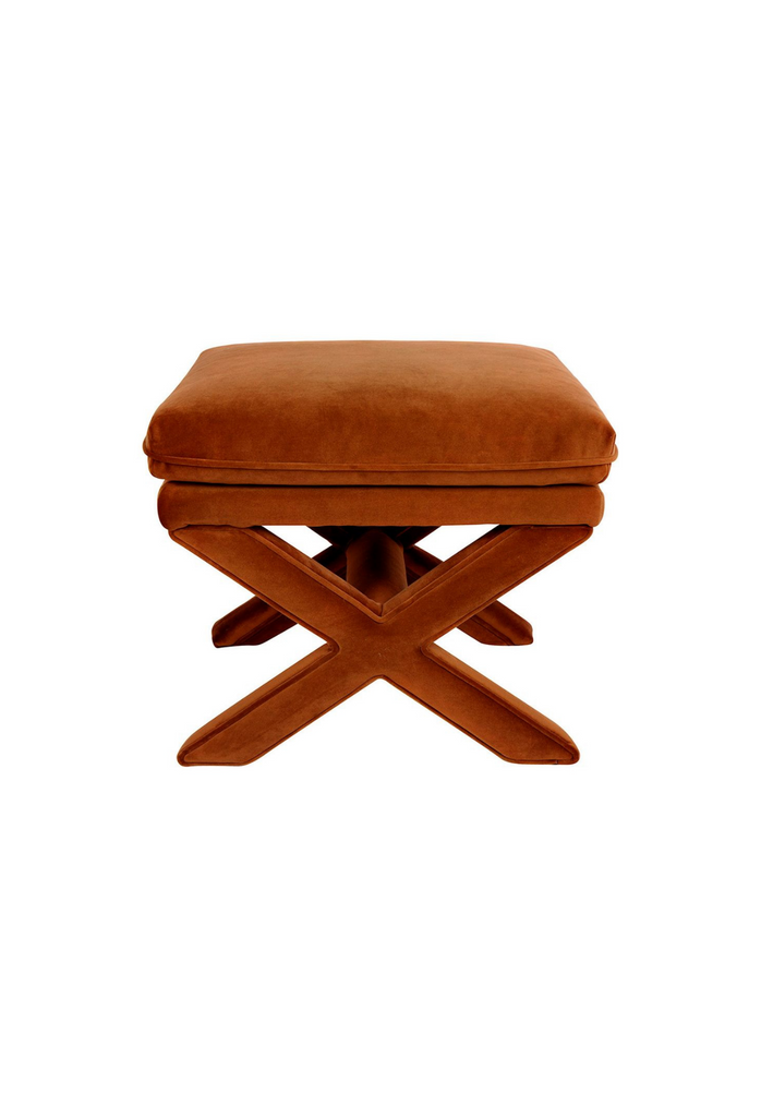 Stylish Stool with a crossed legged base and a generoulsy padded seat fully upholstered in caramel velvet on a white background