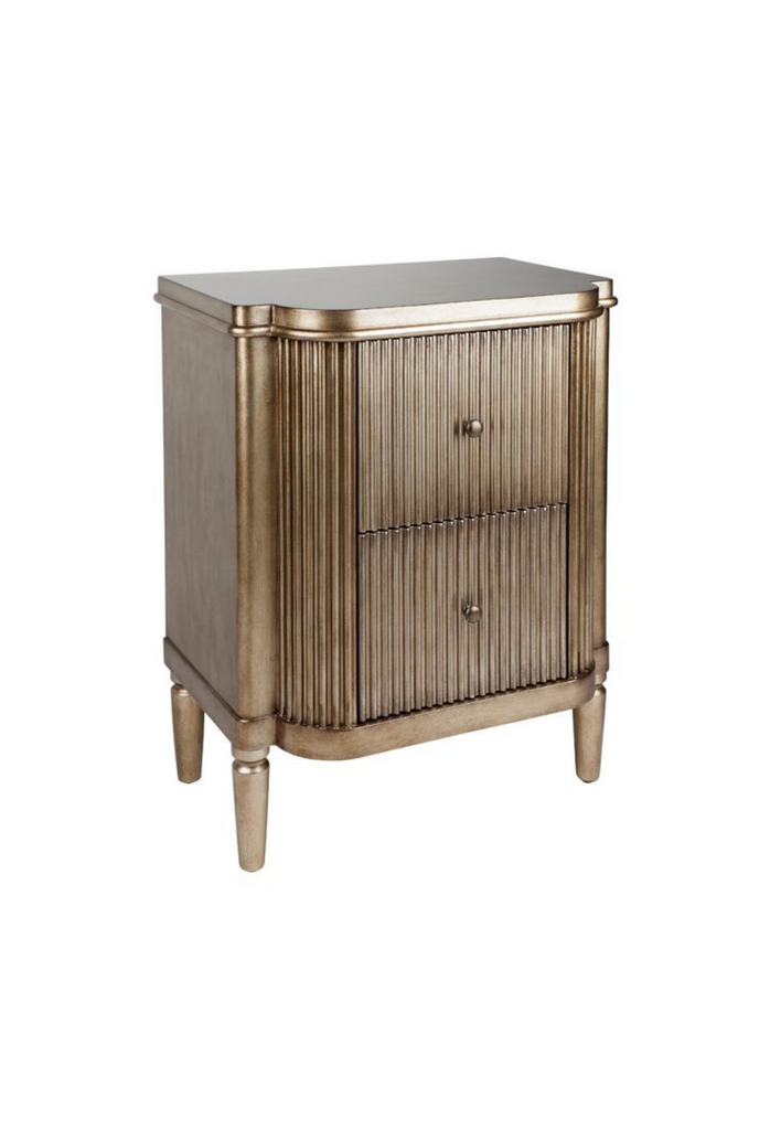 Art-deco style bedside table with round edges, a ribbed antique gold finish and two compact drawers on white background