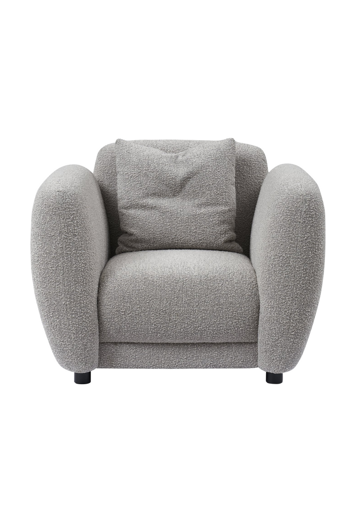 Chunky Armchair with generous back and arm rests fully upholstered in wheat grey boucle with matching cushion and round matte black feet