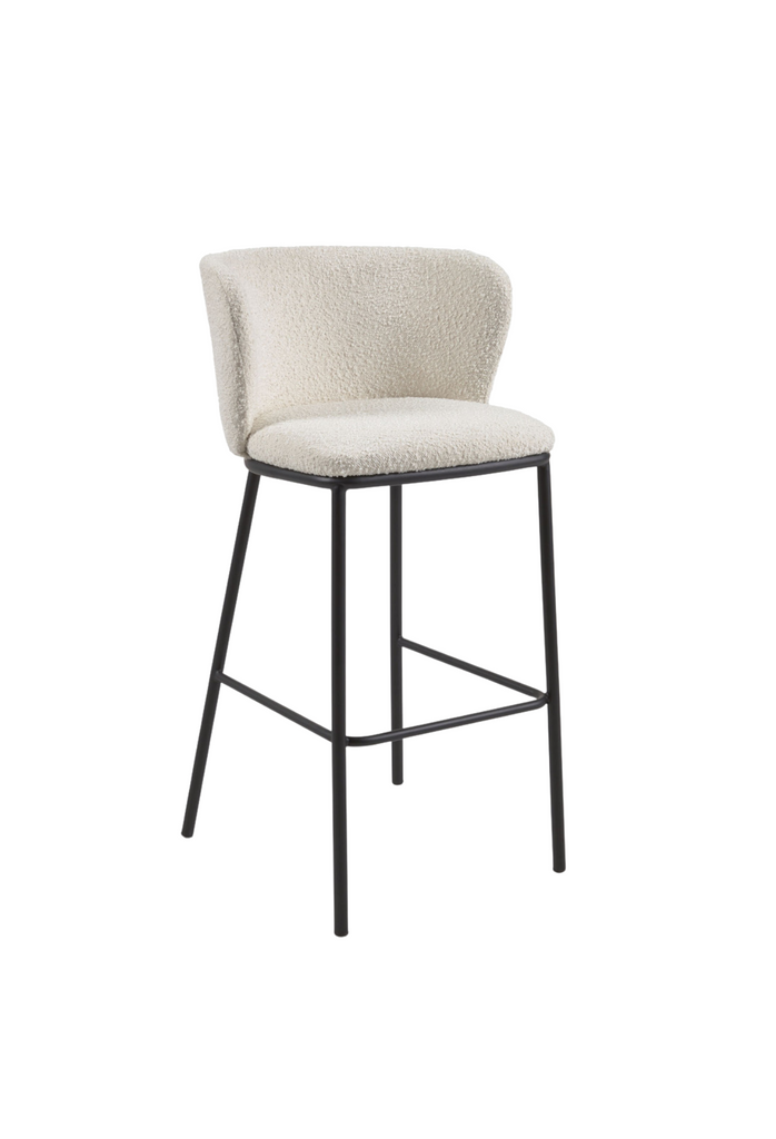 High bar stool with shearling upholstery a curved back rest and black metal legs on a white background