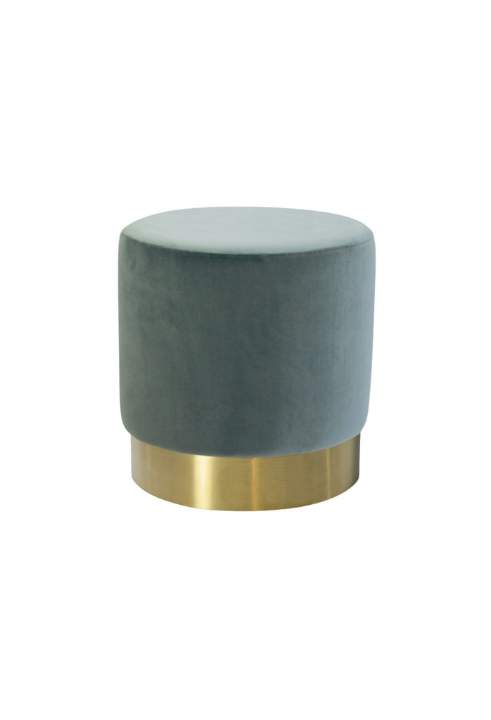 Petite round ottoman fully upholstered in a steel blue coloured velvet with a brushed gold base on a white background