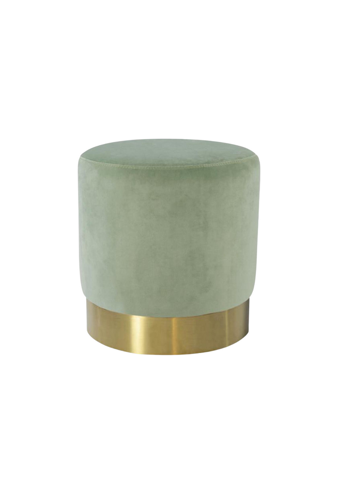 Petite round ottoman fully upholstered in sage green velvet with a brushed gold base on a white background