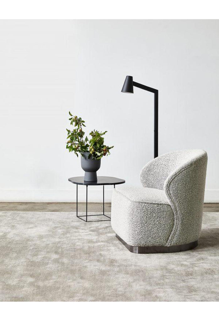 Chunky armless chair with curved back rest fully upholstered in charcoal grey boucle with a solid charocoal coloured metal base