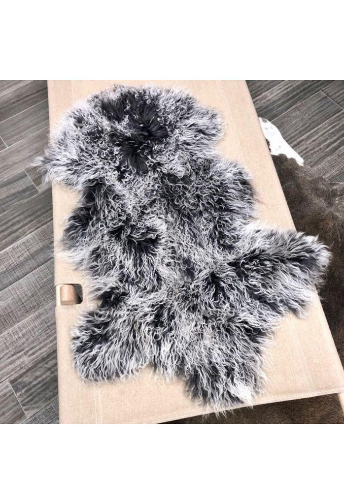 Mongolian Sheepskin in its natural shape and with its unique long hair in charcoal with white tips on white background