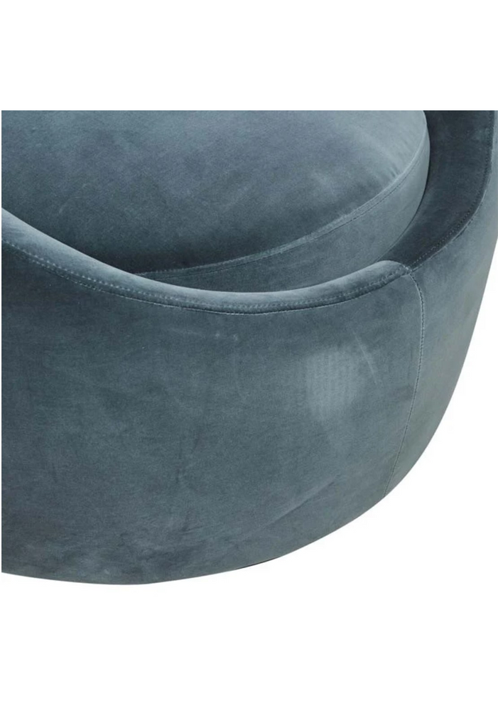 Bold round occasional armchair fully upholstered in charcoal blue velvet with a round black base on white background