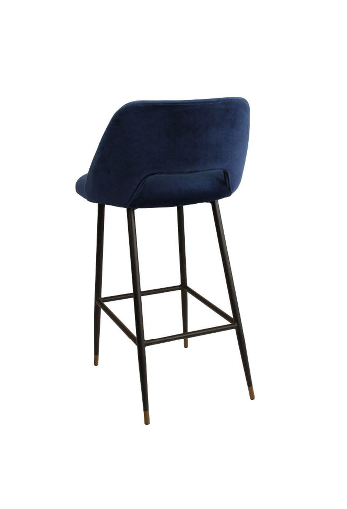 Black bar stool with seat and backrest upholstered in black velvet and metal frame feauring a foot rest on a white background