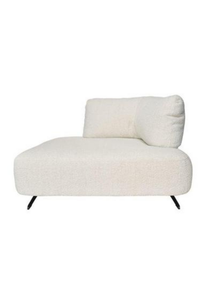 Modern corner lounger fully upholstered in ivory white boucle with matching corner cushion and black metal legs on white background