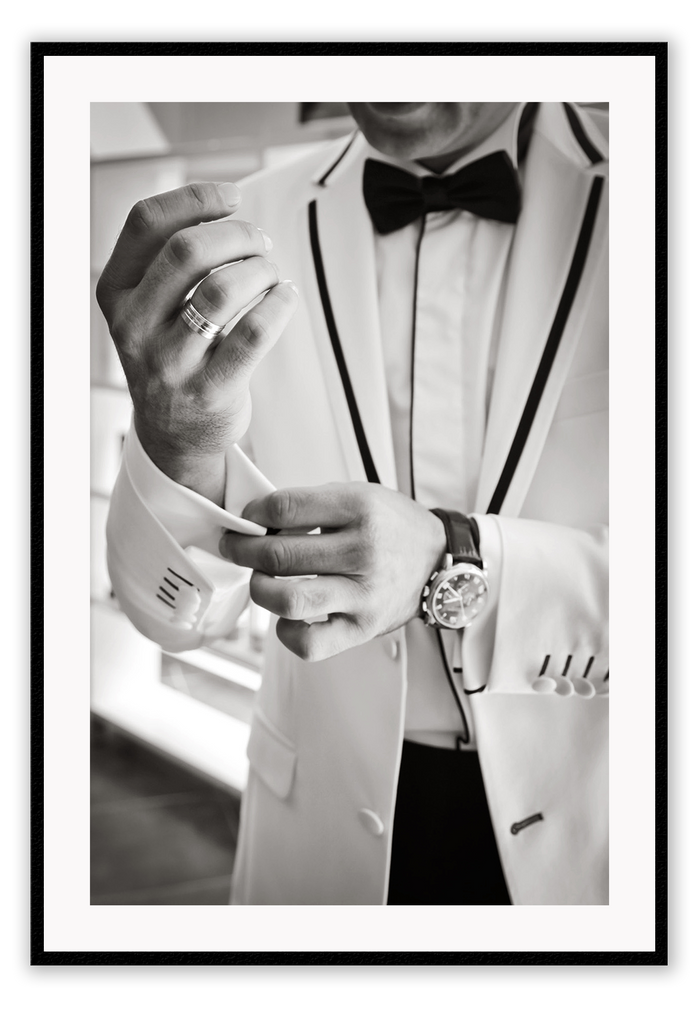 Photography fashion print man adjusting cufflinks on white suit jacket with expensive watch and bow tie 