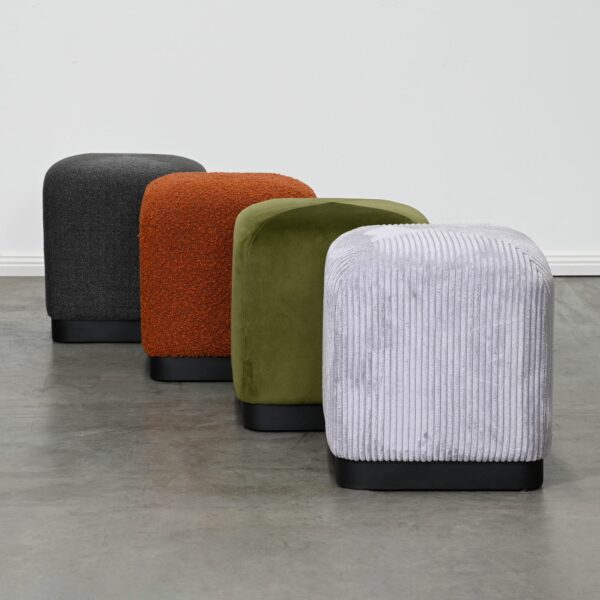 Minimalistic cubic ottoman with soft edges fully upholstered in brick rust boucle on a matte black metal base