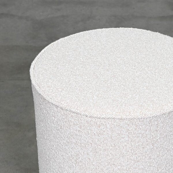 Small Round Ottoman Fully Upholstered in Textured Ivory Oatmeal Coloured Fabric with Piped Edges on White Background