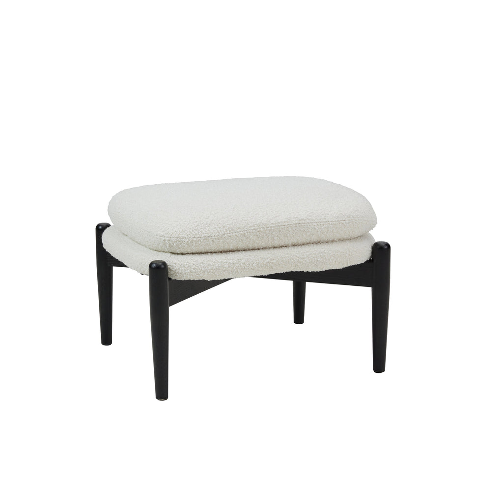 Ottoman stool with two piled up seating cushions in cream boucle and a crossed black wooden base on white background