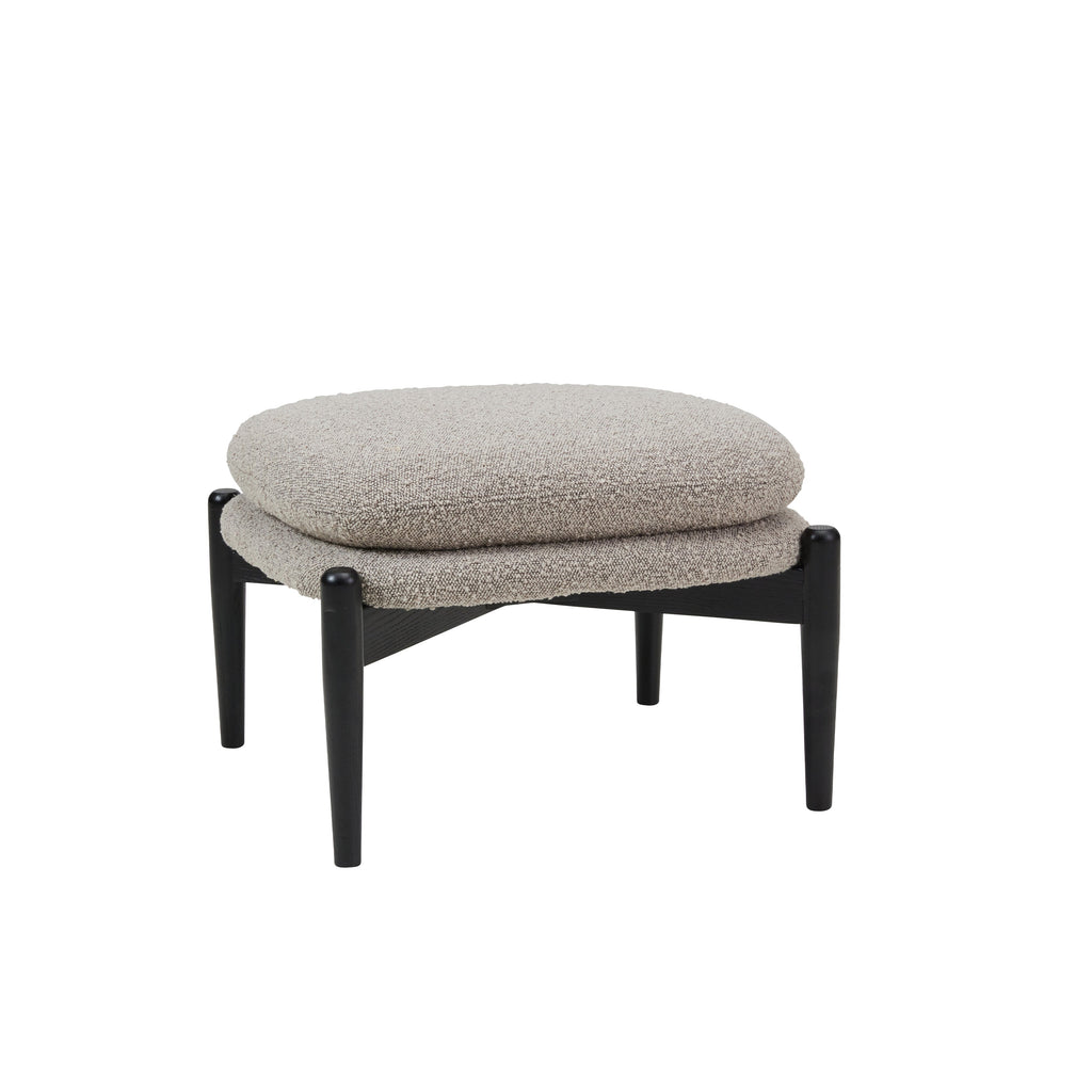 Ottoman stool with two piled up seating cushions in beige boucle and a crossed black wooden base on white background