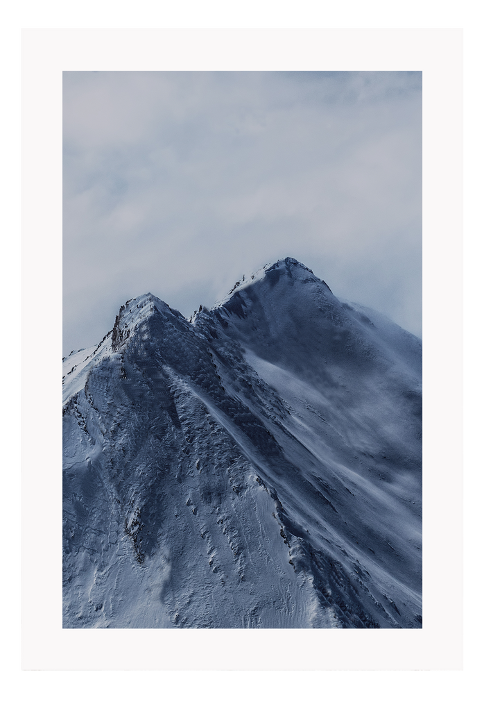 A natural wall art with blue snowy mountain close up and cloudy grey sky.  