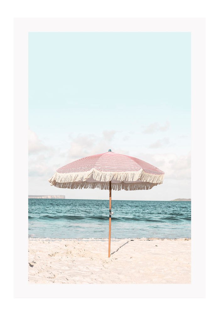 A natural wall art with a pink umbrella on the summer beach in Bali pastel tones and boho style
