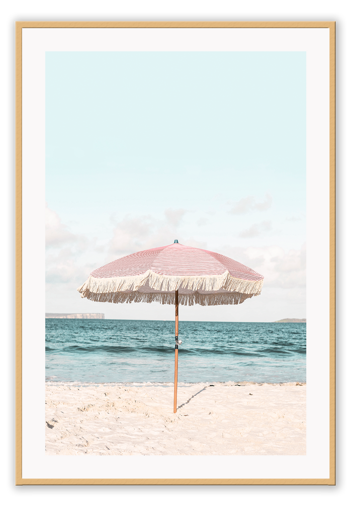 A natural wall art with a pink umbrella on the summer beach in Bali pastel tones and boho style