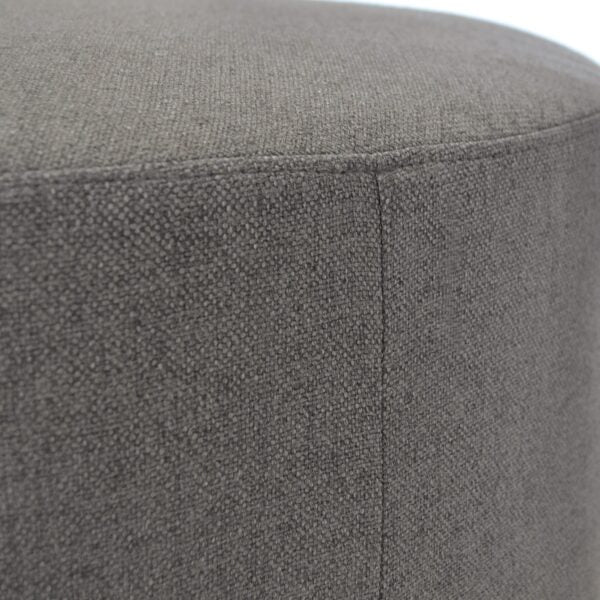 Small round ottoman fully upholstered in a dark grey textured fabric with a black powder-coated metal base