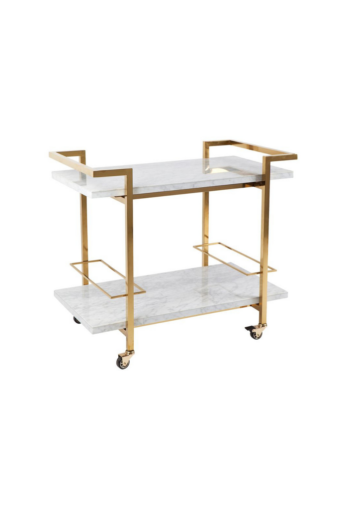Drinks trolley with two rectangular white marble shelves in a geometric shaped gold steel frame with sharp edges on white background
