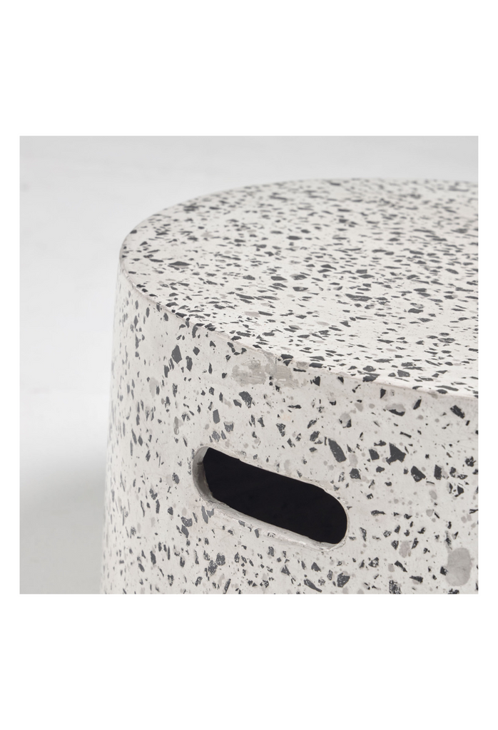 Minimalistic solid round coffee table black and white terrazzo with two handles on a white background