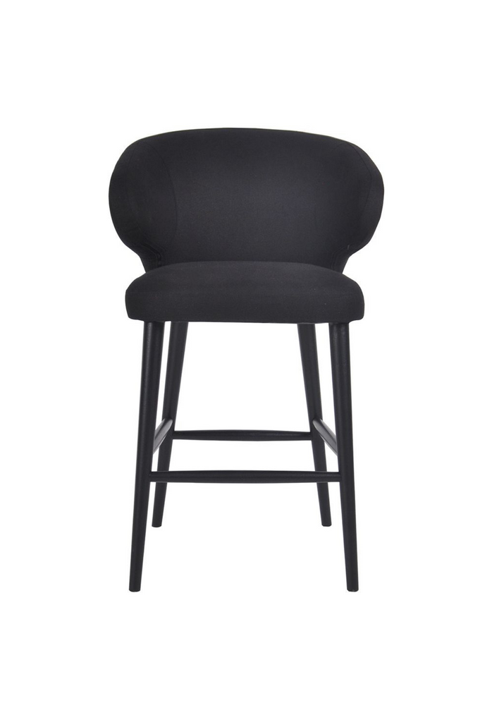 Black linen upholstered kitchen stool with wing back style arms and black timber legs on a white background