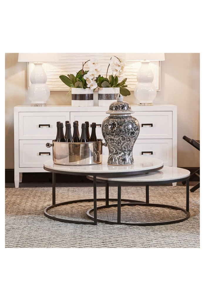 Two Round Nesting Coffee Tables with a White Quartz Looking Stone Top and a Sleek Black Metal Frame on a White Background