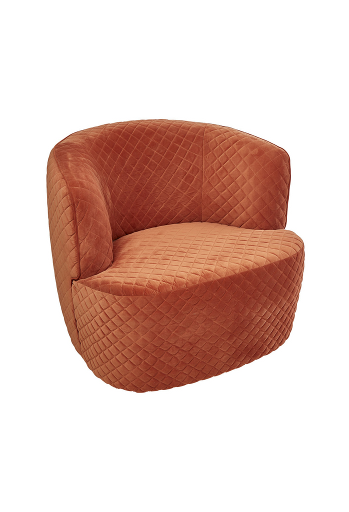 Chunky quilted tub-style armchair fully upholstered in pink orange velvet with curved back and arm rest on a white background