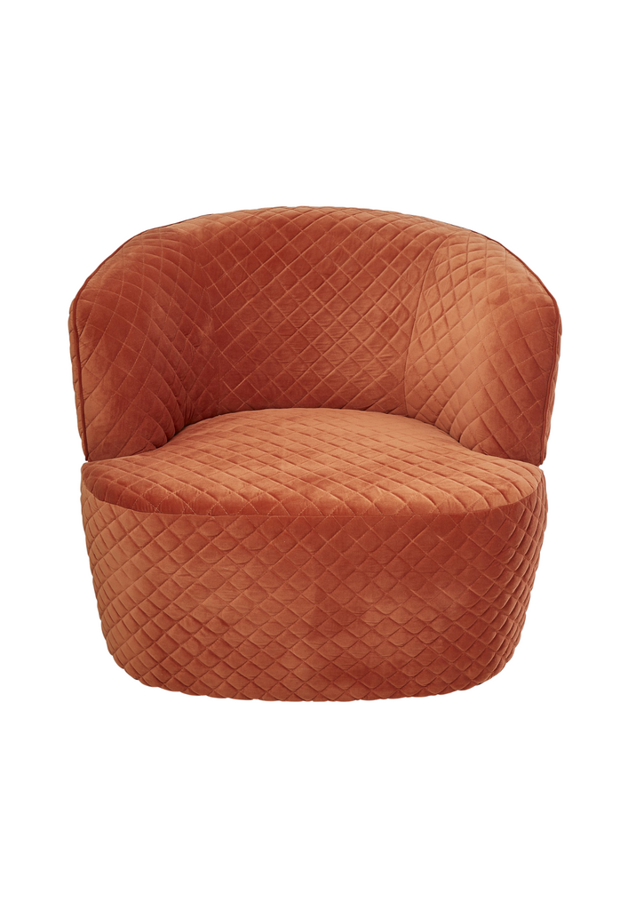 Chunky quilted tub-style armchair fully upholstered in pink orange velvet with curved back and arm rest on a white background