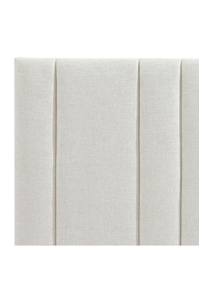 Free standing rectangular panelled bedhead fully upholstered in a cream natural coloured linen on white background