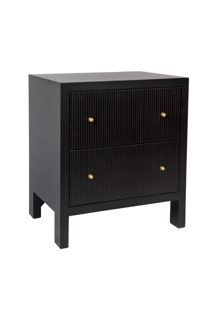 Black bed side table with two fluted drawers and brushed gold handles on a white background