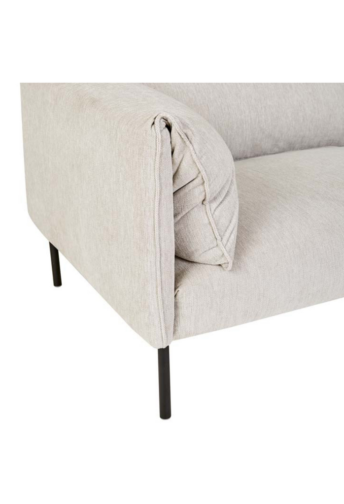 Modern 3 seater sofa with back and arm rests folded over upholstered in a cream fabric with thin cylindrical black metal legs