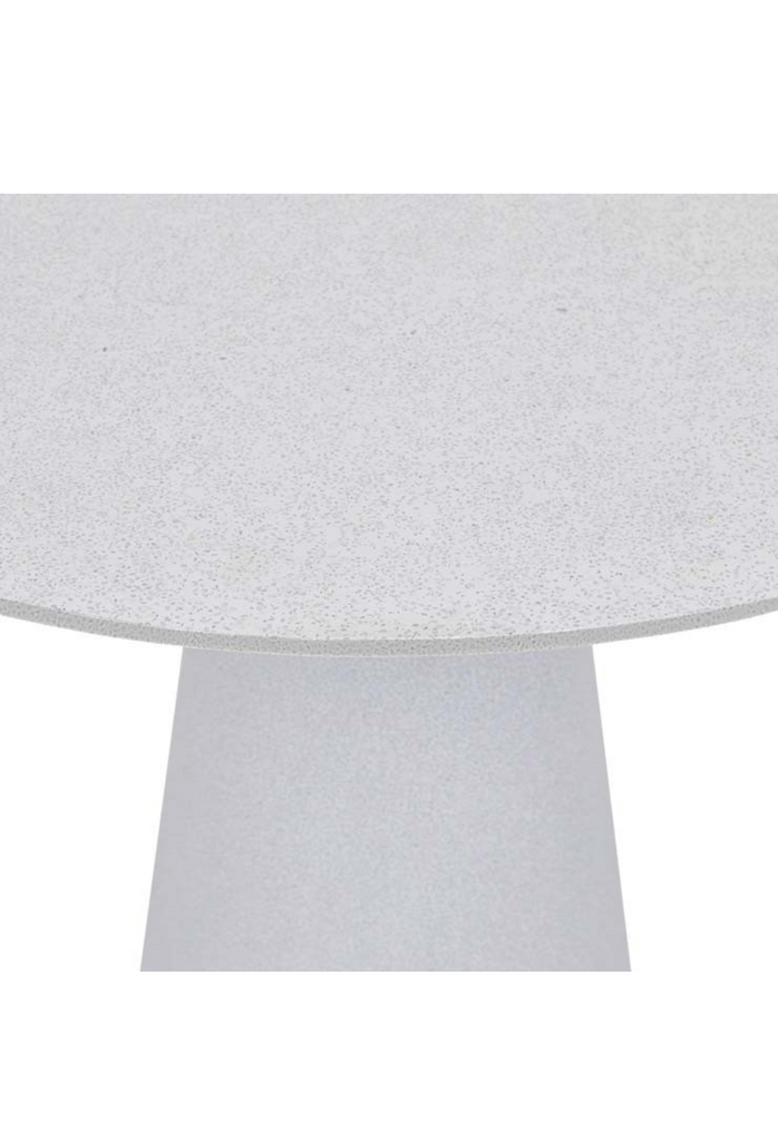 Modern white spotted outdoor table with round table top and pillar base made of fibreglass on white background
