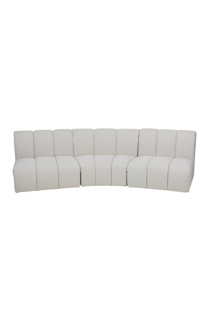 Modular 3 seater sofa with three curved modules fully upholstered in cream boucle feautring stitching details creating a padded look