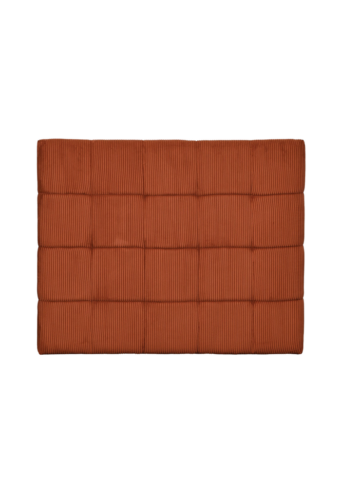 Modern padded bedhead fully upholstered in a soft burnt orange cord fabric with square shaped stiching details on a white background