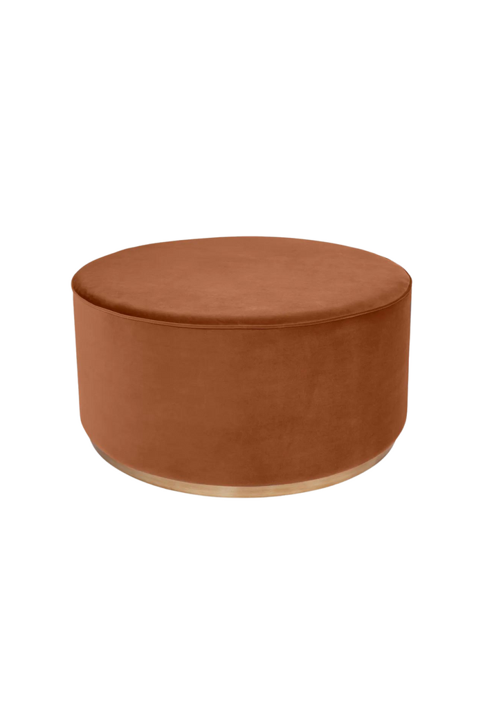 Large solid round ottoman upholstered in caramel velvet with matching piped edges and a brushed gold metal base