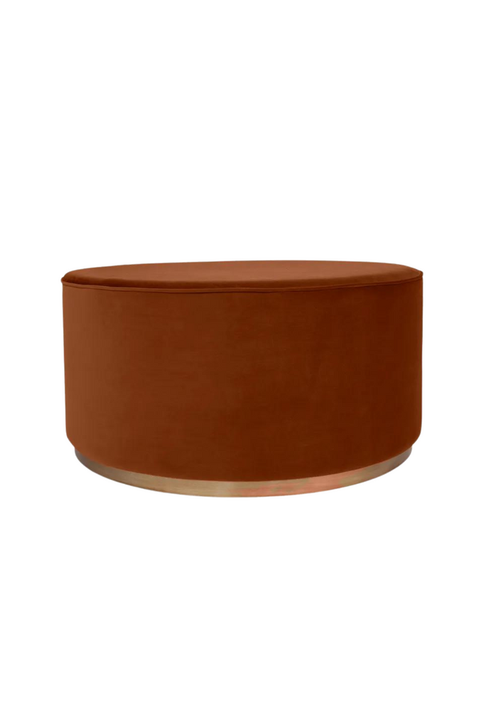 Large solid round ottoman upholstered in caramel velvet with matching piped edges and a brushed gold metal base