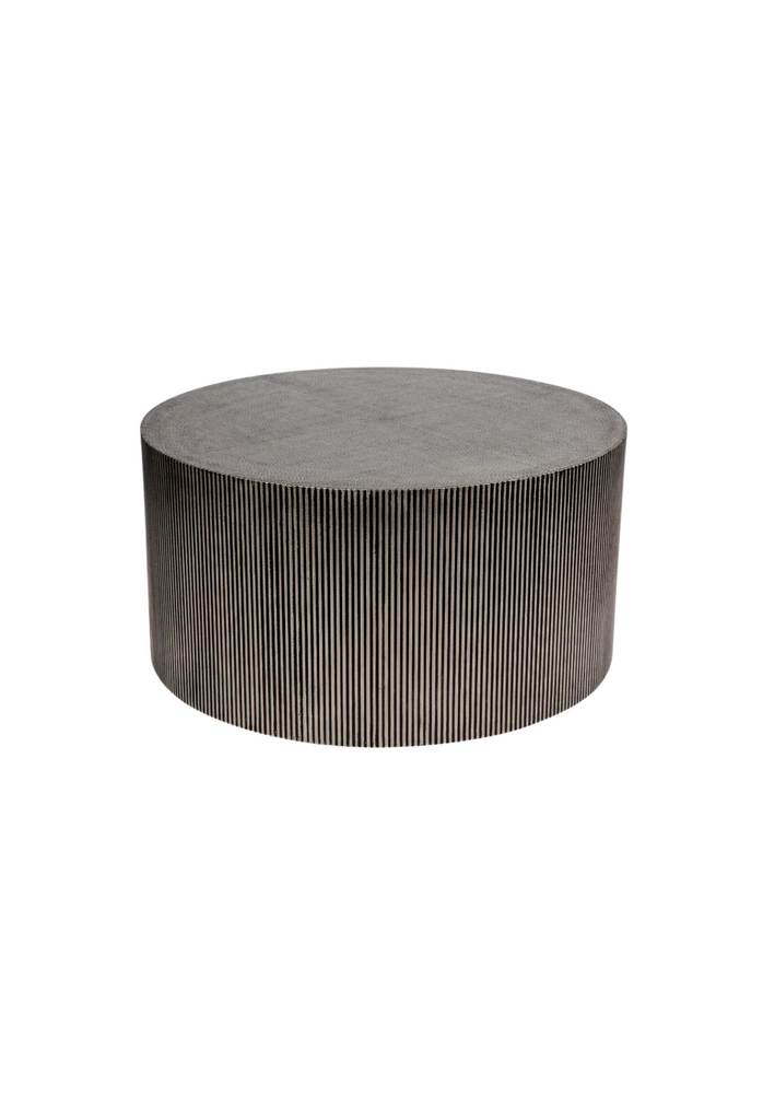 Solid round coffee table with fluted base in dark grey and black tones on a white background