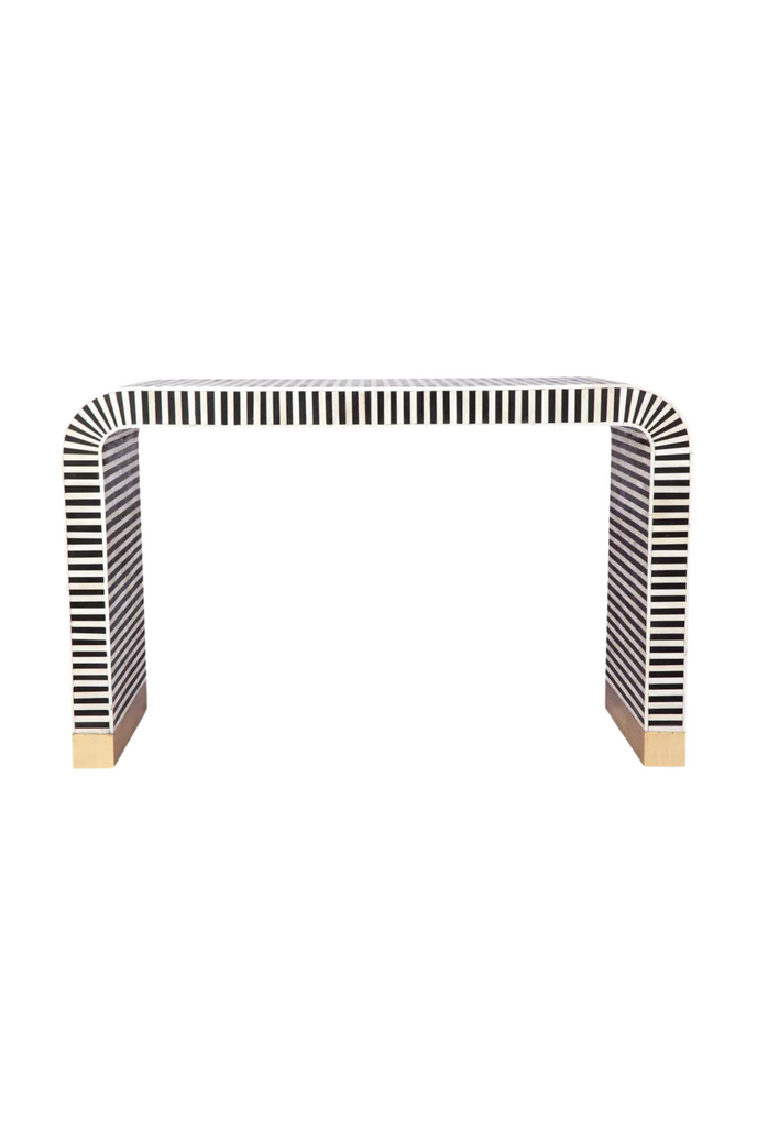 Modern curved console table with black bone inlay creating black and white striped look and brass clad base