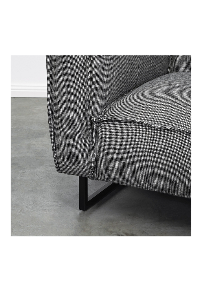Textured Dark Grey arm chair with straight lines and stitched edge upholstery detailing on sleek black metal legs