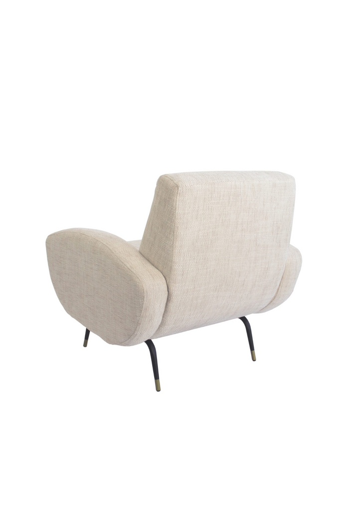 Natural linen armchair with two chunky arm rests featuring round edges and four slim black metal legs with brass finish cups