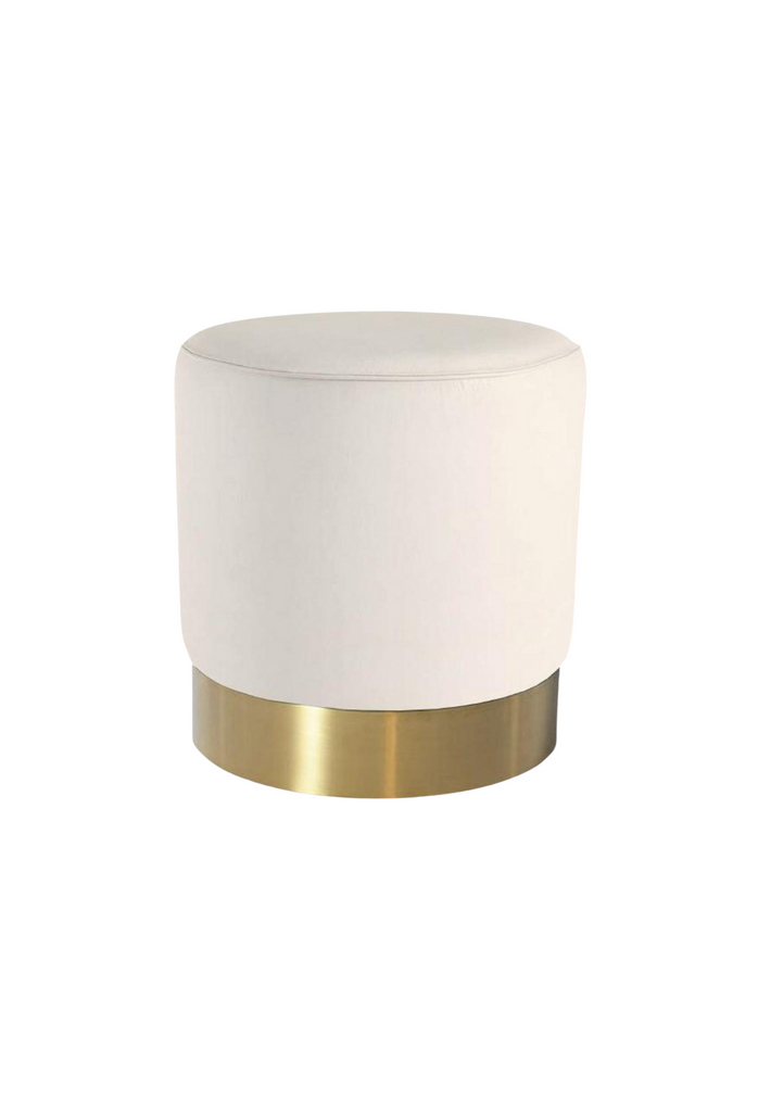 Petite round ottoman fully upholstered in white velvet with a brushed gold base on a white background