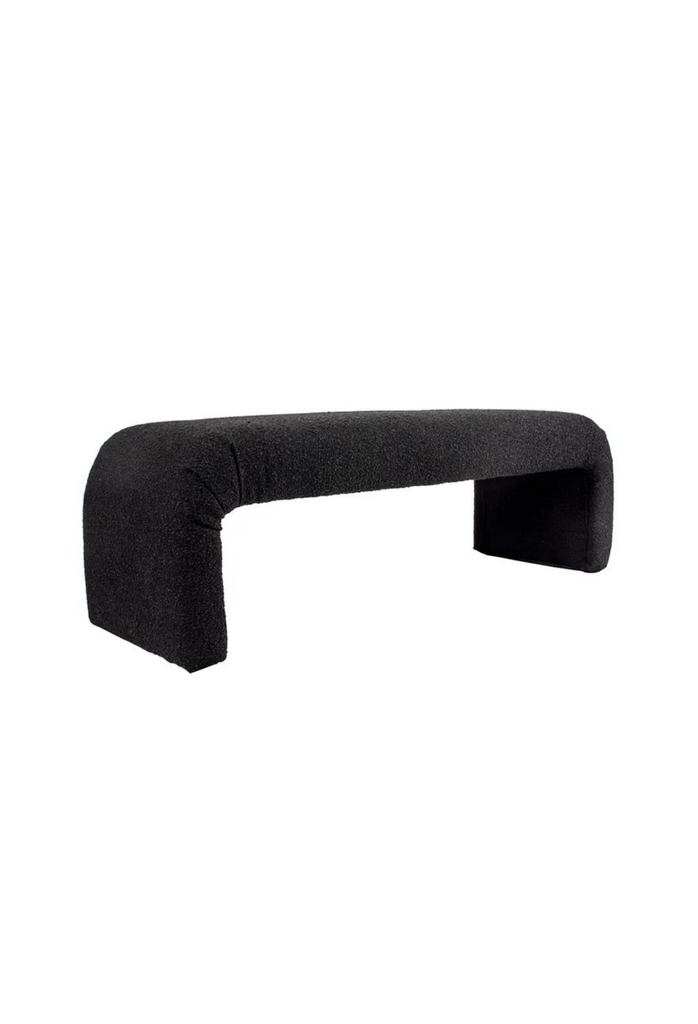 Minimalistic Bench with Curved Seat Merging Into Two Chunky Legs Fully Upholstered in Black Boucle on White Background