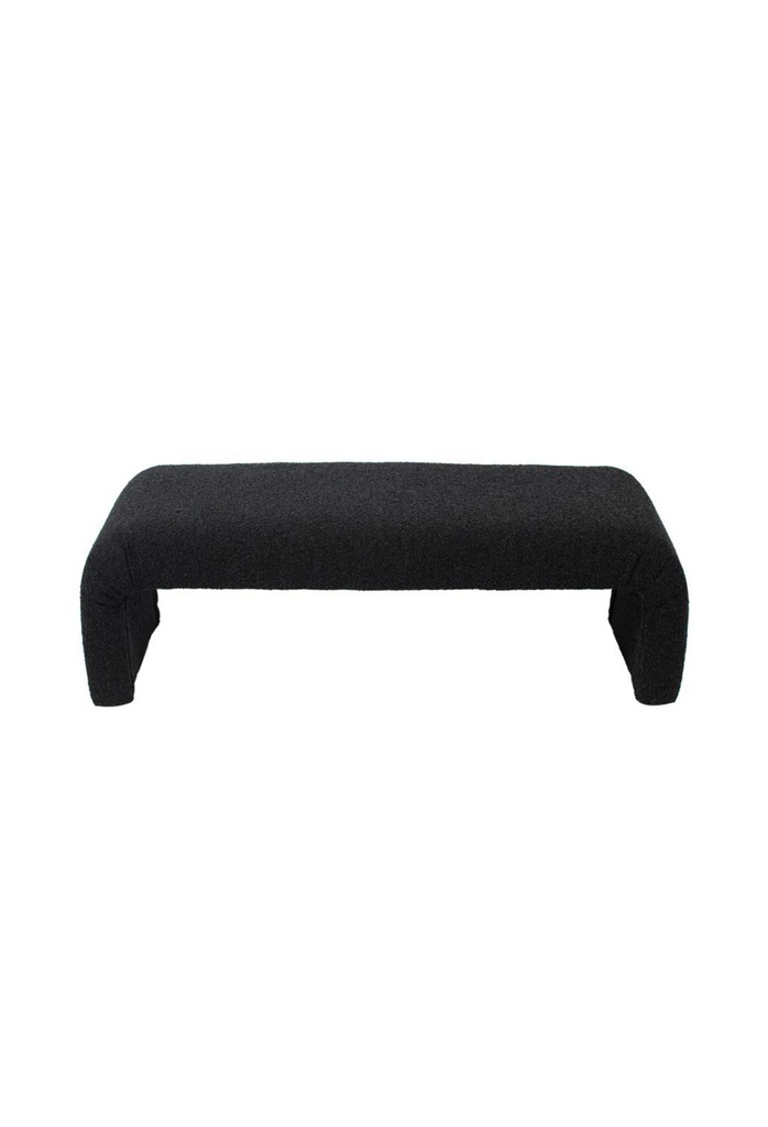 Minimalistic Bench with Curved Seat Merging Into Two Chunky Legs Fully Upholstered in Black Boucle on White Background