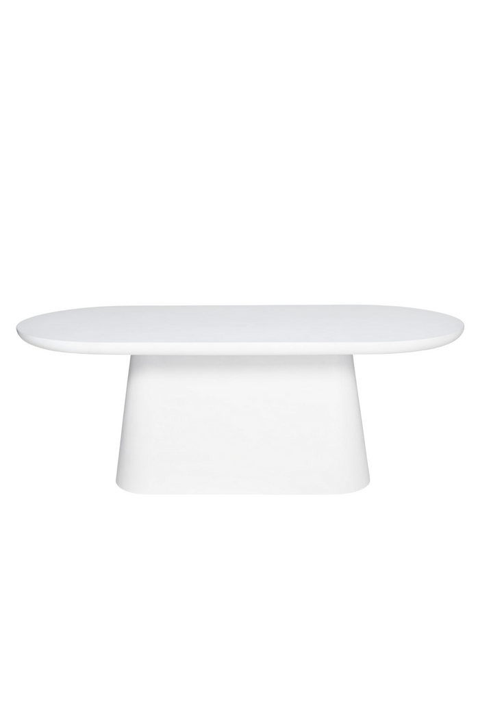 Simplistic oval white dining table with round edges and a solid chunky base on a white background
