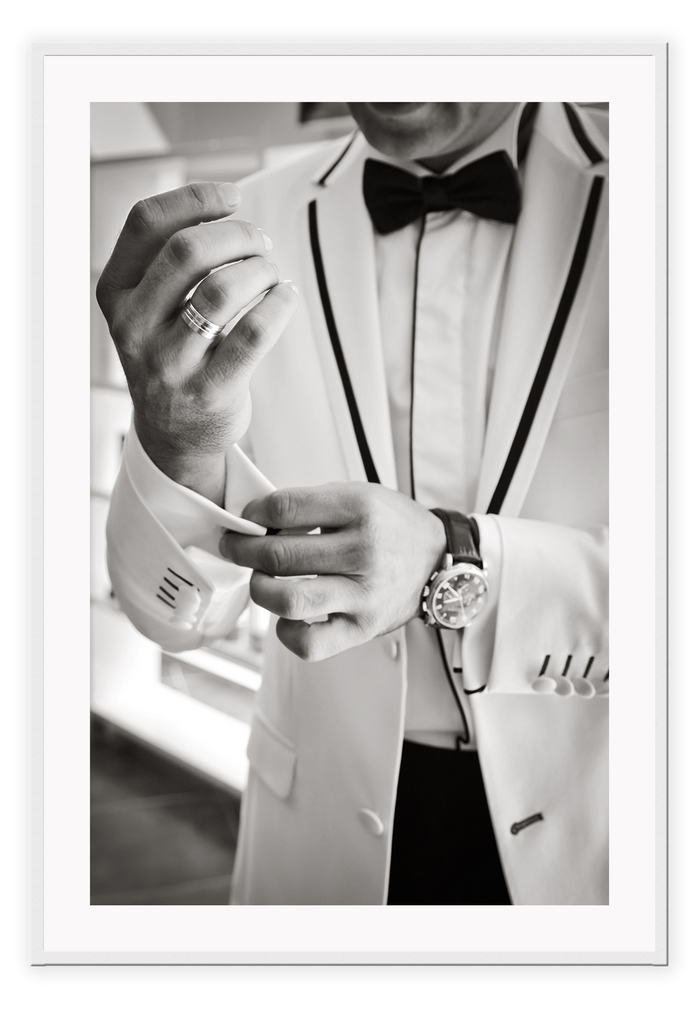 Photography fashion print man adjusting cufflinks on white suit jacket with expensive watch and bow tie 