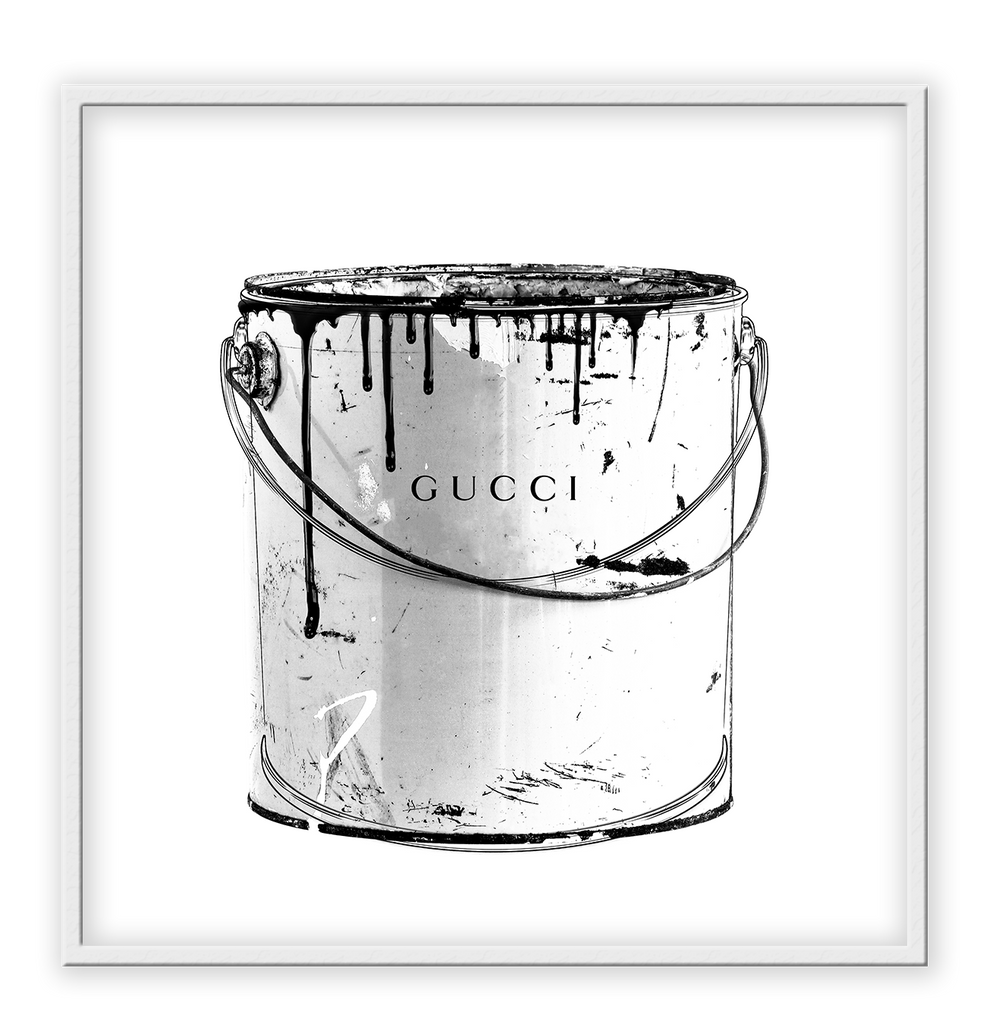 A black and white fashion wall art with a paint jug and Gucci fashion label wrinting on it. 