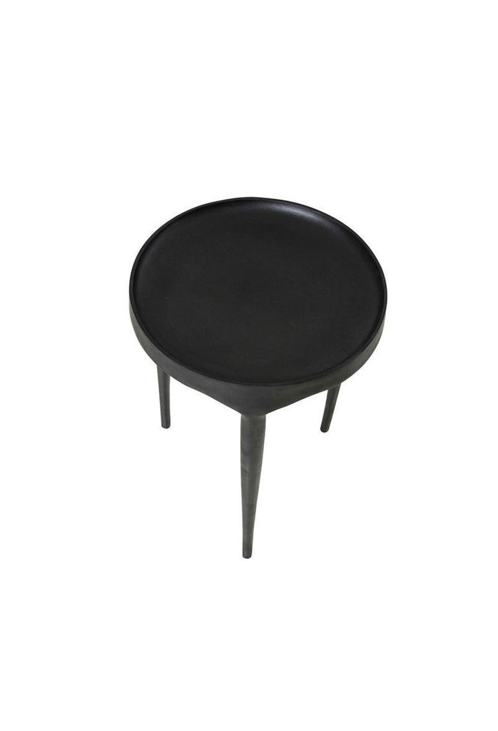 Modern matt black metal coffee table with three long legs merging into a round concave table top on white background