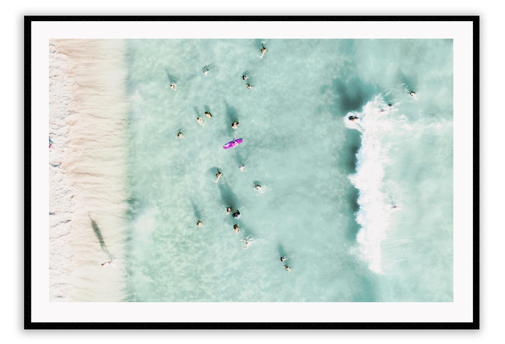 Coastal style photography beach landscape print with people swimming in blue water from a birds eye view.