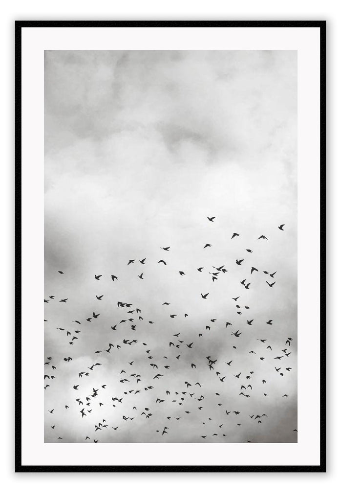 A black and white natural wall art of cloudy sky with black birds hovering above the sky.