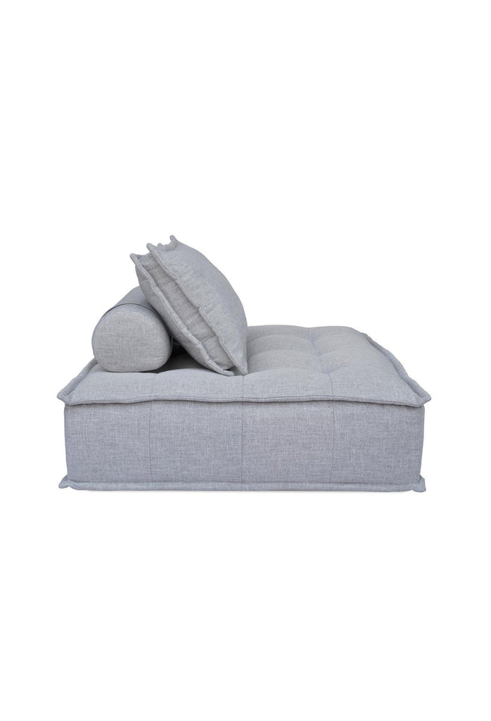 Square shaped lounger with button tufting fully upholstered in a textured grey fabric with matching cushion on a white background