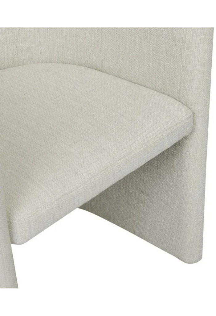 Petite armchair upholstered in fine natural white tweed with a curved back rest and a cut out base on a white background